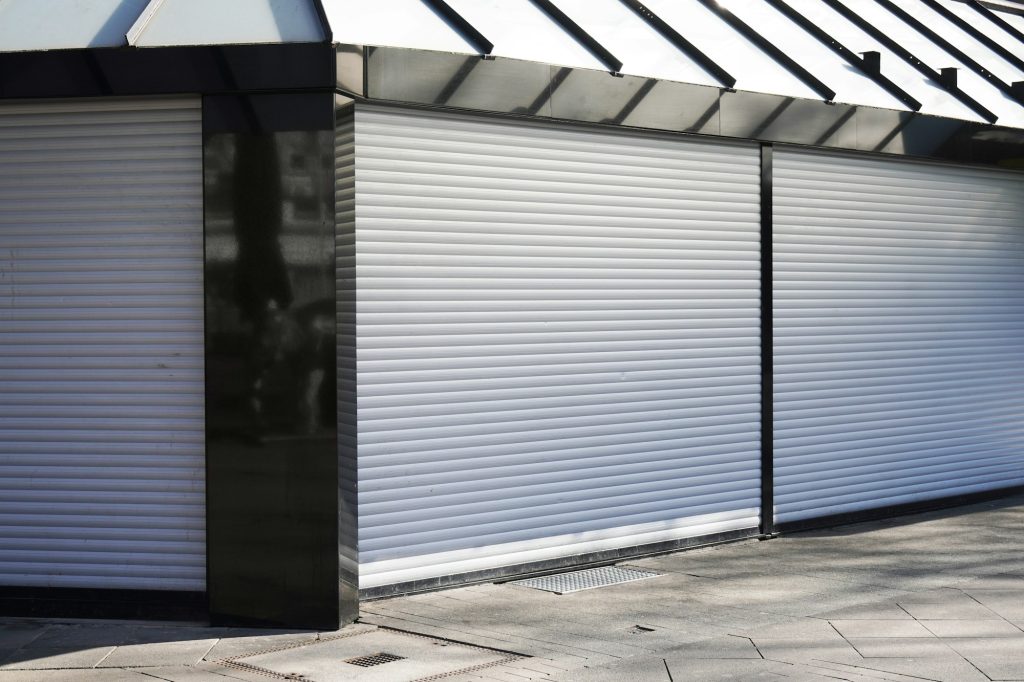 Are Roller Shutters Any Good for Security? closed business shop or store front with roller shutters. economy crisis and recession concept.